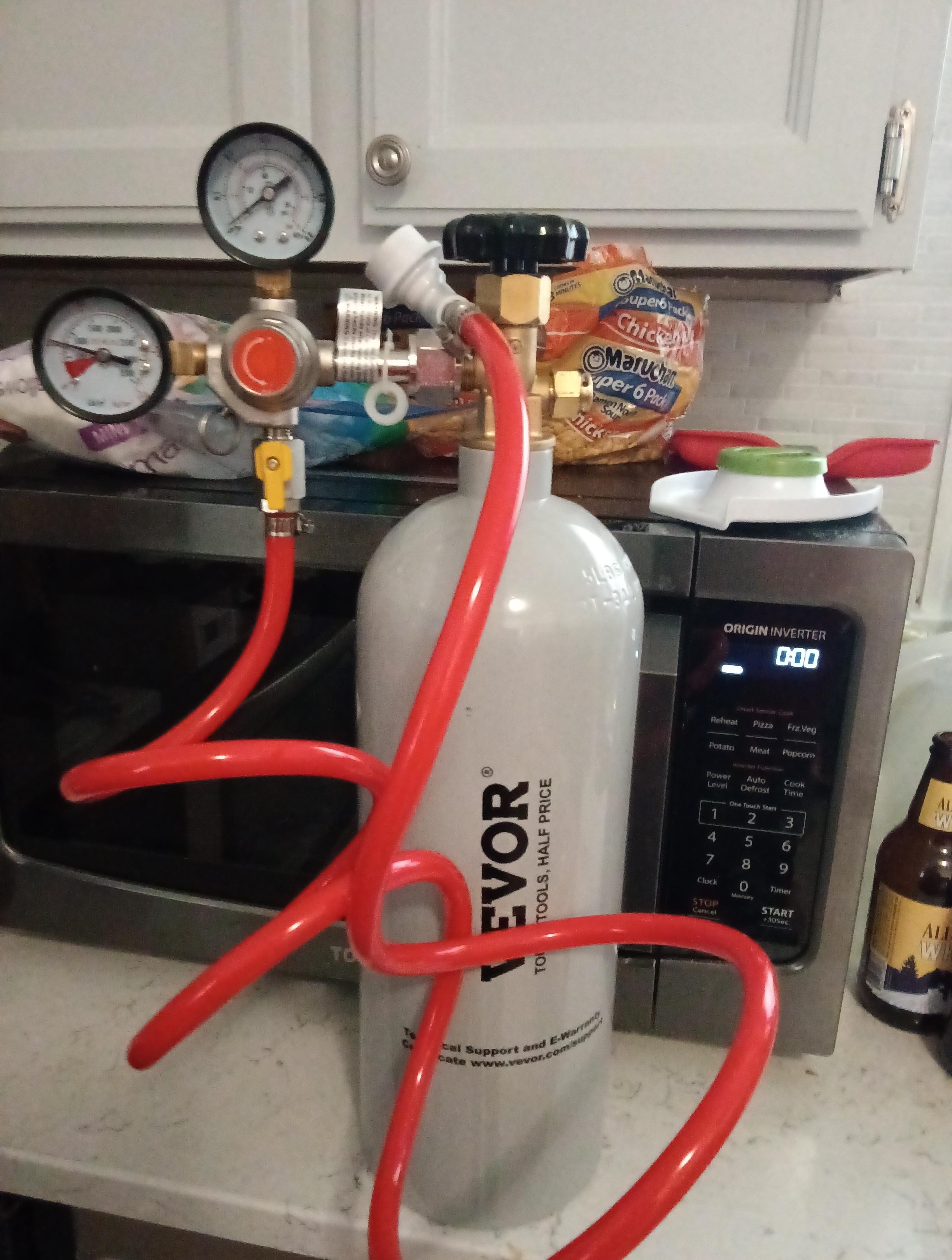 CO2 tank with a pressure regulator on it, and a hose with a ball joint meant for carbonation on the other end of the pressure regulator